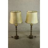 A pair of possibly Dutch brass turned candlesticks converted to floor standing lamps, with shades.