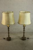 A pair of possibly Dutch brass turned candlesticks converted to floor standing lamps, with shades.