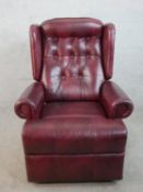 A 20th century oxblood leather Chesterfield style reclining armchair raised on casters.