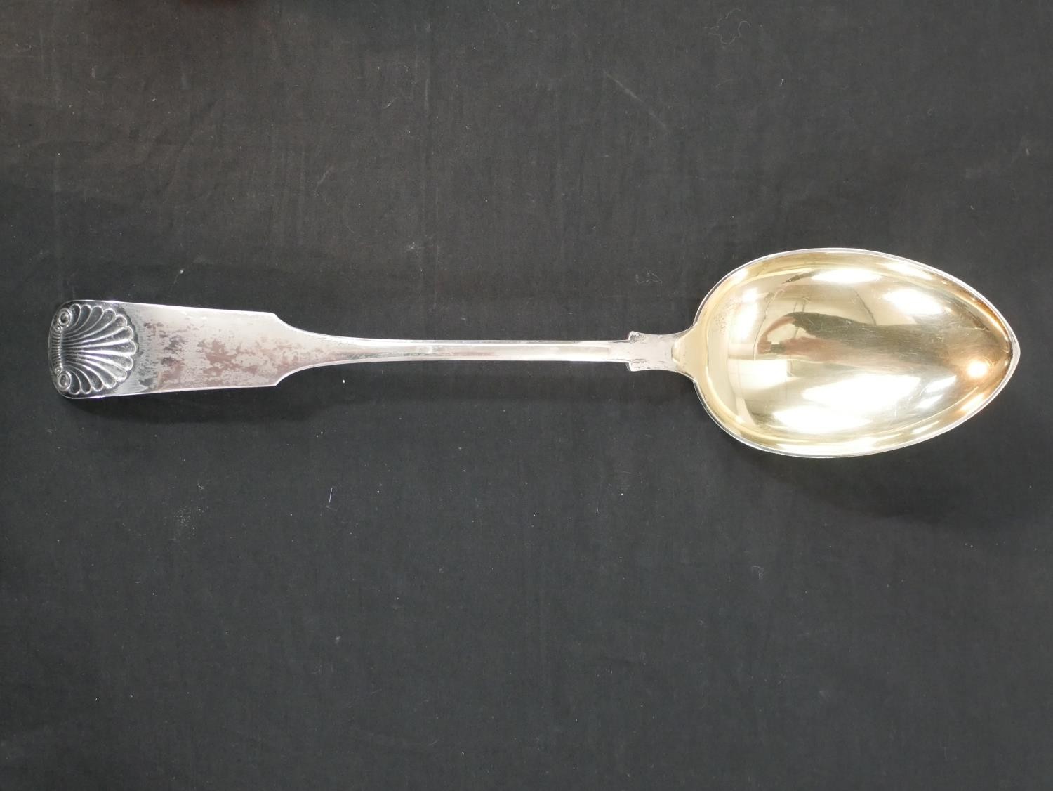 A large Danish white metal fiddle and shell pattern serving spoon, with gilded bowl, stamped J.G.