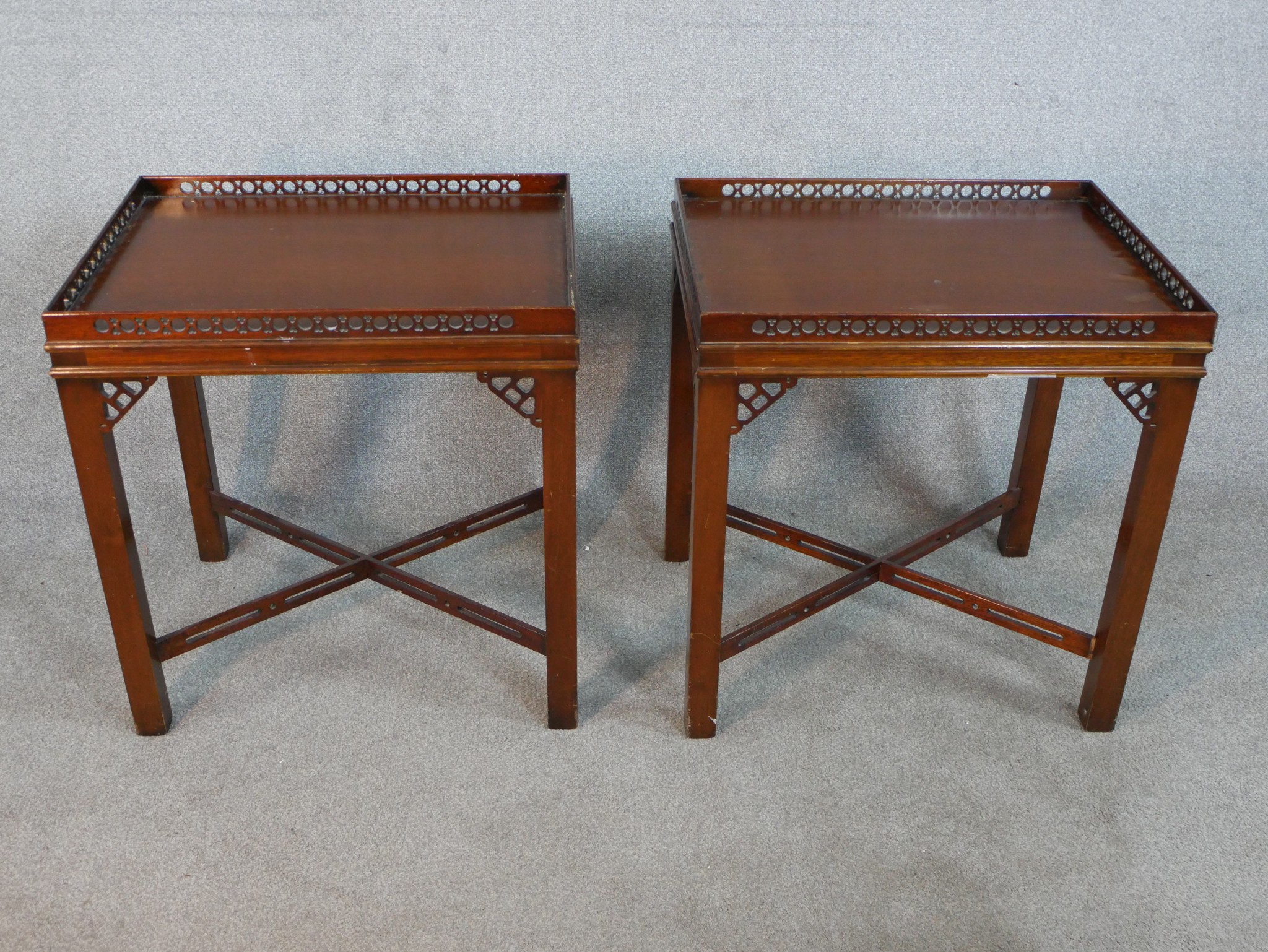 A pair of reporoduction mahogany lamp tables in Chippendale style, of rectangular form with a