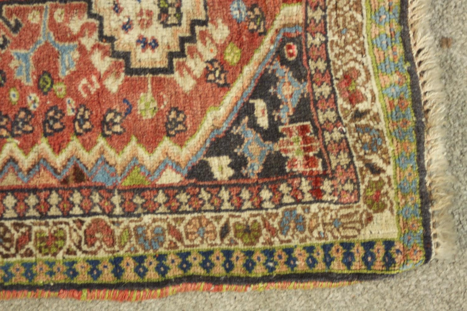 A hand woven red ground Persian Quashqai rug. L.88 W.53cm. - Image 4 of 5