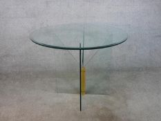 A contemporary circular occasional table, the plate glass top with a bevelled edge on a cross form