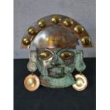 A patinated copper and brass Inka mask. H.30 W.24cm