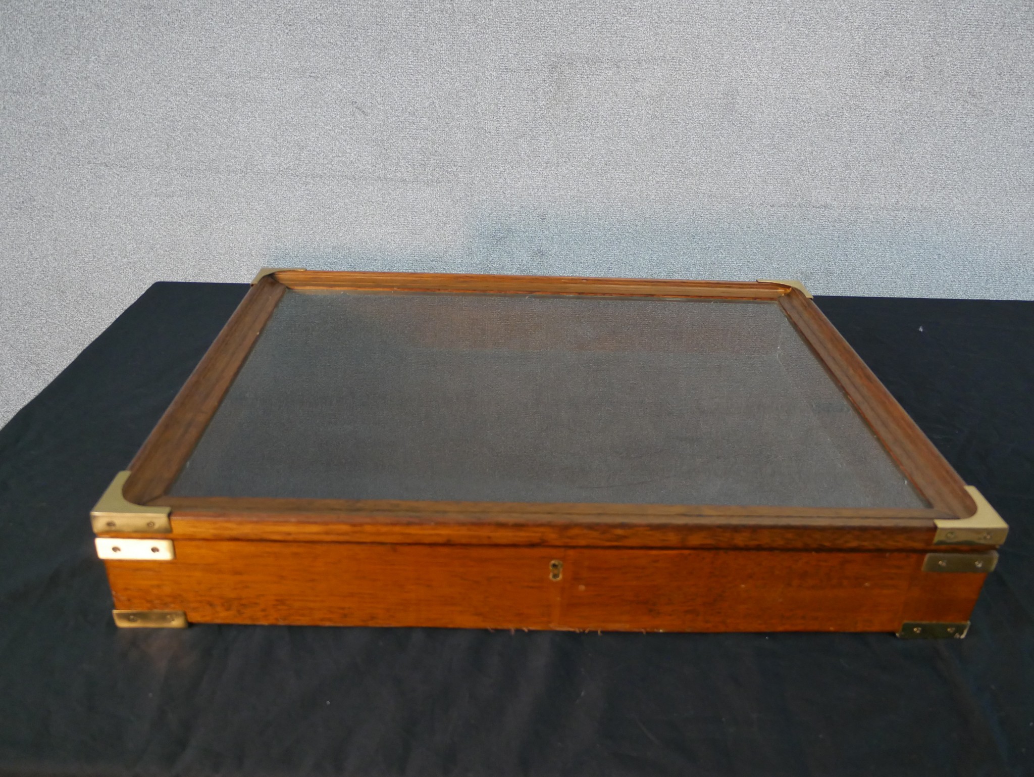 An early 20th century walnut tabletop display cabinet or bijouterie cabinet with a glazed lid and