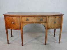 A Regency mahogany bowfront sideboard; with central drawer flanked by two cupboards; raised on