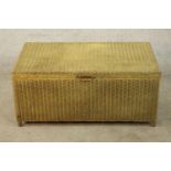 A 1930s painted Lloyd loom style ottoman/ blanket trunk raised on short supports, H.41 W.91 D.53cm.