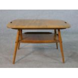 A 20th century blonde elm and beech Ercol two tier occasional tray table, model number 457, raised