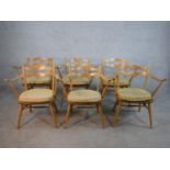 A set of six mid 20th century Ercol blonde elm and beech open arm and splat back dining chairs model