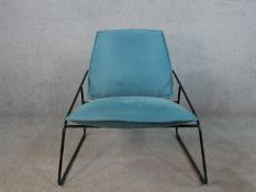 A contempory black painted metal framed Ikea lounge chair with blue upholstered cushions.