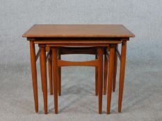 A set of three mid 20th century Danish teak intersliding tables raised on square tapering