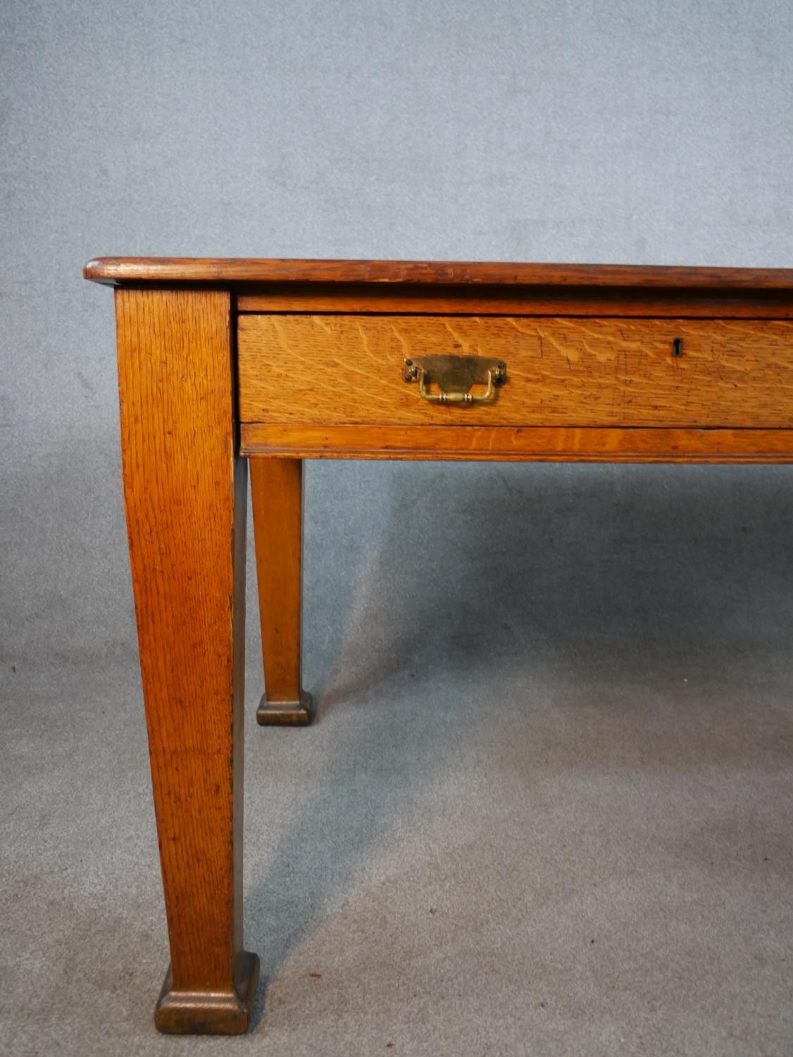 An early 20th century oak two drawer writing table raised on tapering supports terminating in square - Image 2 of 6