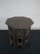 An Indian ornately carved hardwood octagonal occasional table, the top carved with a foliate design,