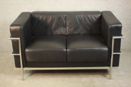 After Le Corbusier, an LC2 two seater sofa, with black leather upholstery and a chromed tubular