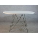 A Magis Tavolo XZ3 circular table having a circular white laminate table top
