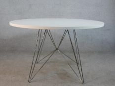 A Magis Tavolo XZ3 circular table having a circular white laminate table top