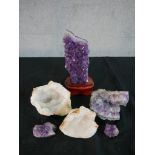 A collection of rocks and minerals, including a large amethyst crystal on stand and two crystal
