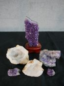 A collection of rocks and minerals, including a large amethyst crystal on stand and two crystal