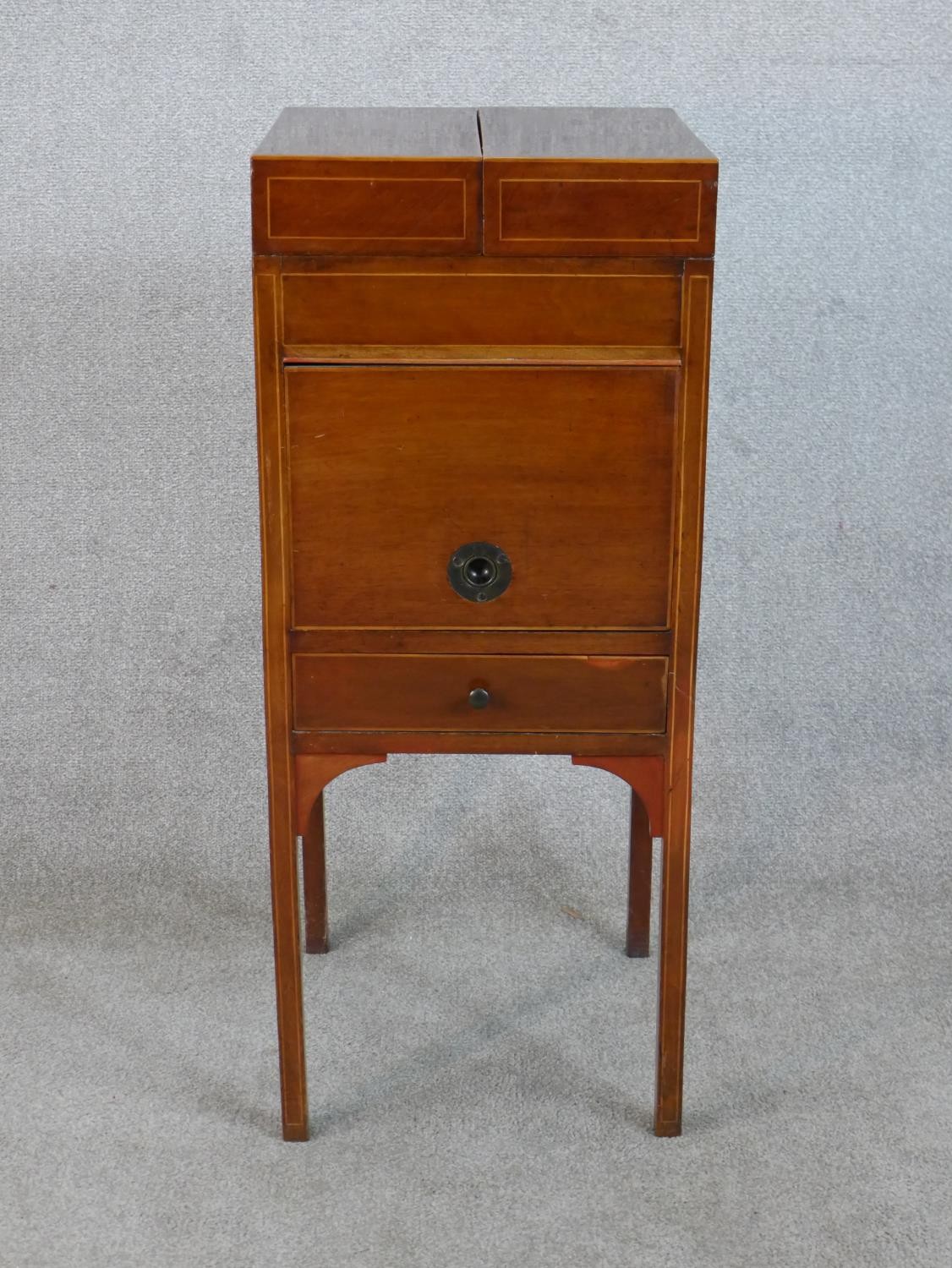 A George III crossbanded mahogany foldout washstand with single door and drawer raised on square