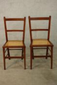 A pair of early Edwardian mahogany framed bar back single bergere chairs raised on tapering supports