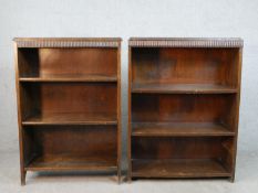 A near pair of early 20th century walnut open bookcases, each with fluted friezes over shelves, H.