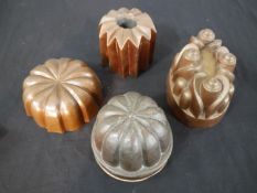 A collection of four Victorian and later copper jelly moulds, some with stamped marks. H.11 W.15 D.