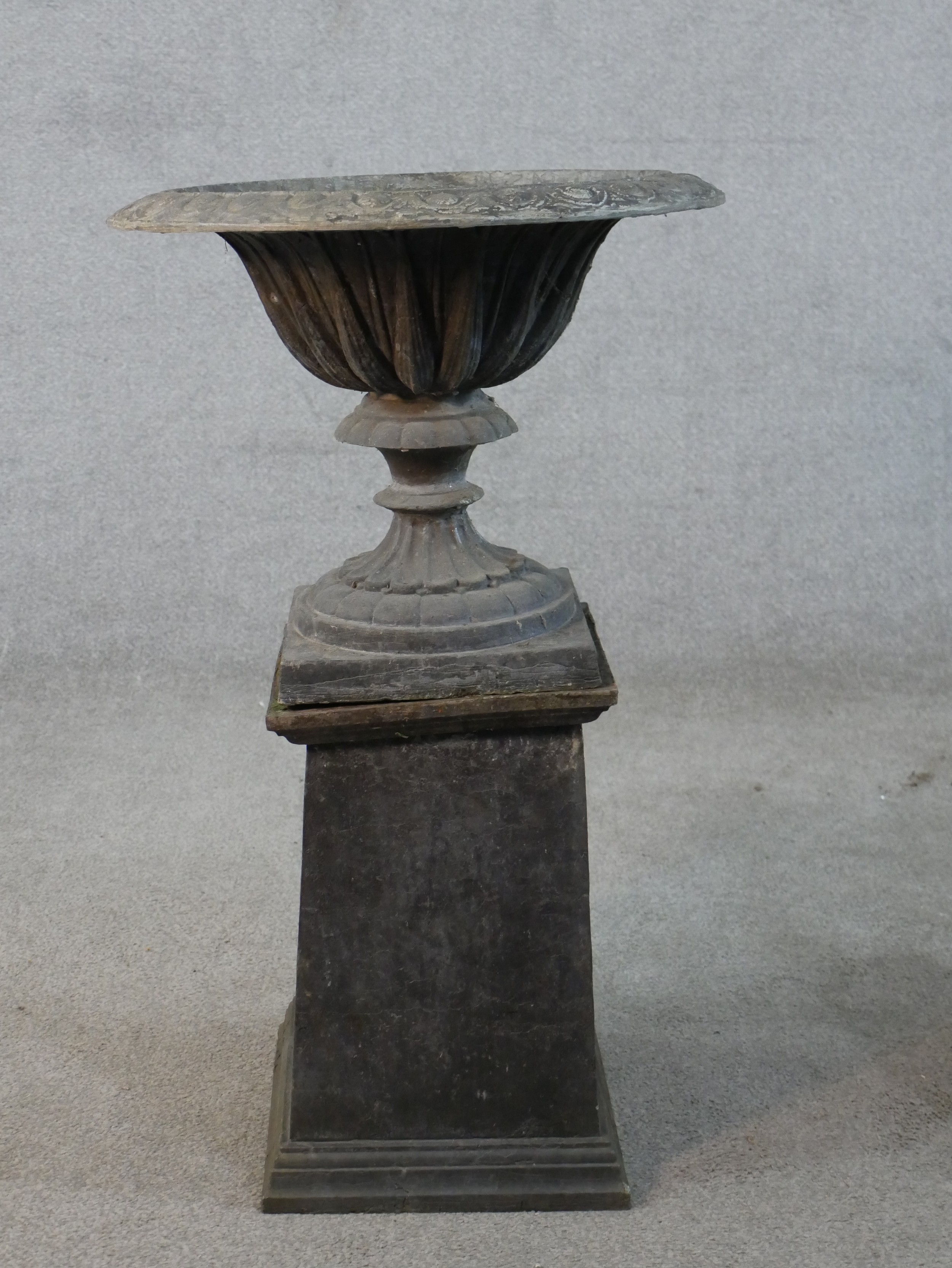 A 19th century fluted lead garden urn on turned central column terminating in square foot raised