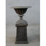 A 19th century fluted lead garden urn on turned central column terminating in square foot raised