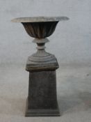 A 19th century fluted lead garden urn on turned central column terminating in square foot raised