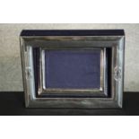 A silver framed blue velvet lined open box with a separate silver photo frame, matching design.