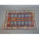 A rust ground hand made Turkish Indigo rug. W.140 D.91cm