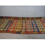 A large Kelim with all over geometric design in blue, yellow and red. L.425 W.165cm