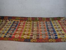 A large Kelim with all over geometric design in blue, yellow and red. L.425 W.165cm