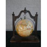 A Thomas Blakemore reproduction terrestrial globe, hanging from a cast iron frame on a mahogany