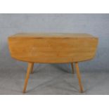 A 20th century Ercol elm top drop flap table, model 383, raised on four splayed tapering supports,