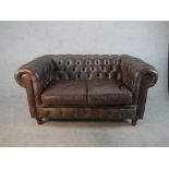 A late 20th century brown leather two seater Chesterfield sofa, with buttoned back and arms and