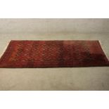 A red ground Baluch rug with all over geometric pattern. L.190 W.88cm.