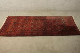 A red ground Baluch rug with all over geometric pattern. L.190 W.88cm.