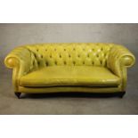 A yellow leather Chesterfield two seater sofa by Baxter - Italy, with a buttoned back and