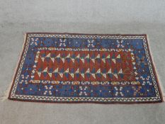 A rust ground hand made Turkish Konya rug. W.142 D.79cm