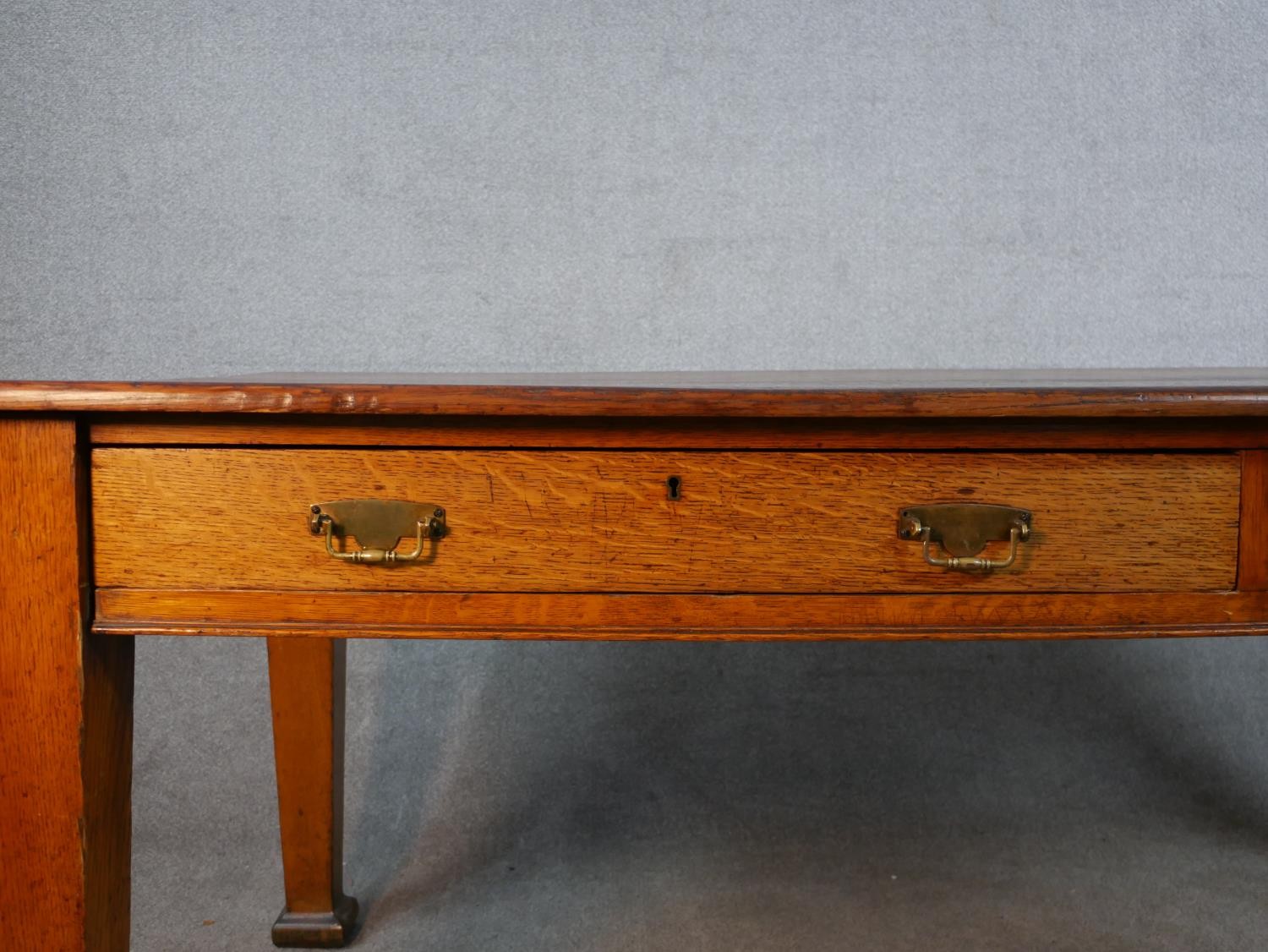 An early 20th century oak two drawer writing table raised on tapering supports terminating in square - Image 3 of 6