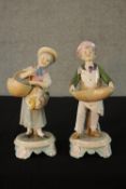 A pair of late 19th / early 20th century Continental porcelain figures of a man and a woman carrying