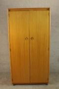 A circa 1960's Schreiber teak wardrobe with a pair of doors, opening to reveal hanging space and