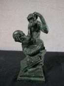A composite sculpture depicting a monkey as The Thinker, with a skull in its hand, seated on a stack