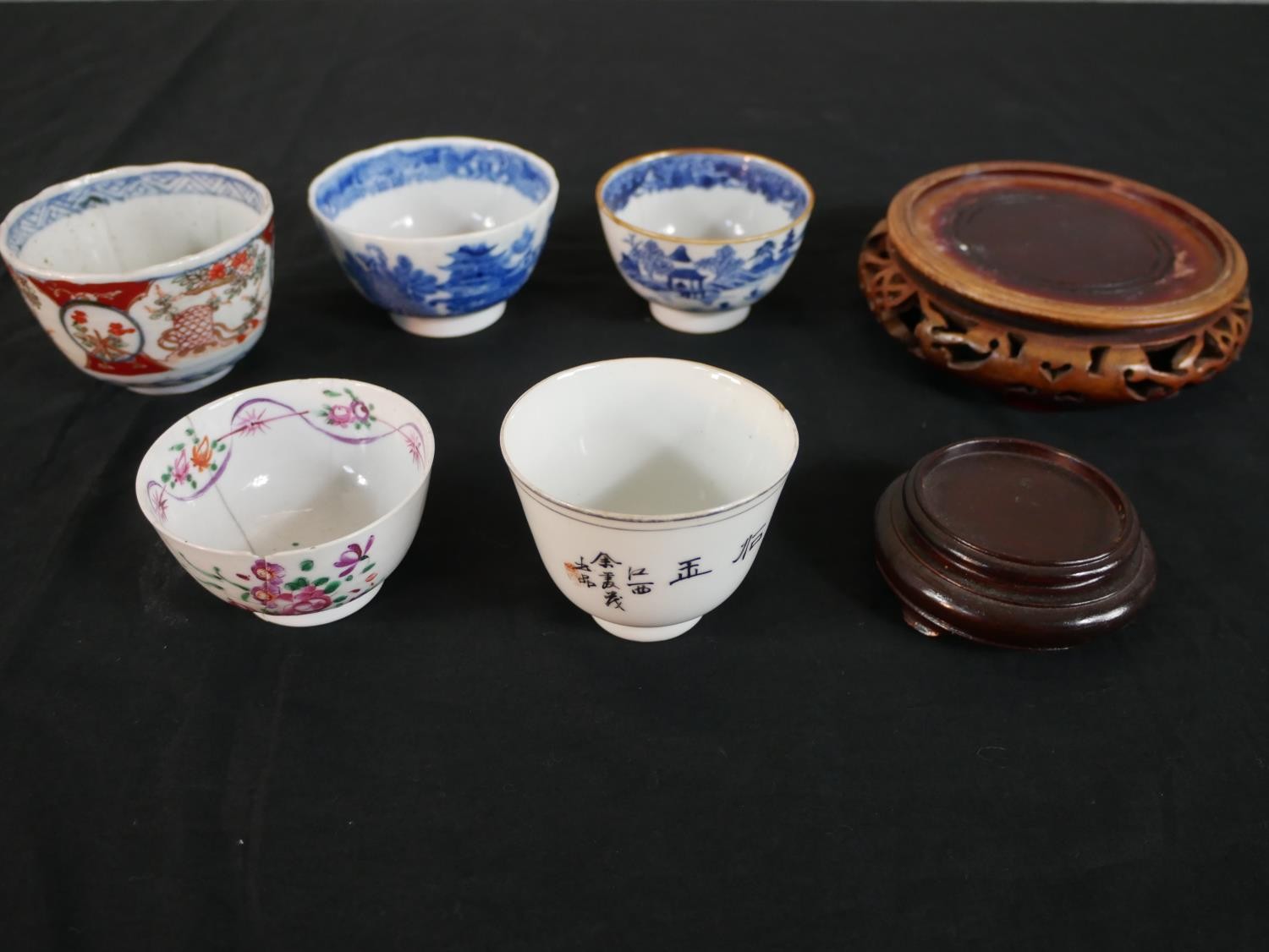 A collection of five 19th century Chinese tea bowls along with two carved and pierced hardwood