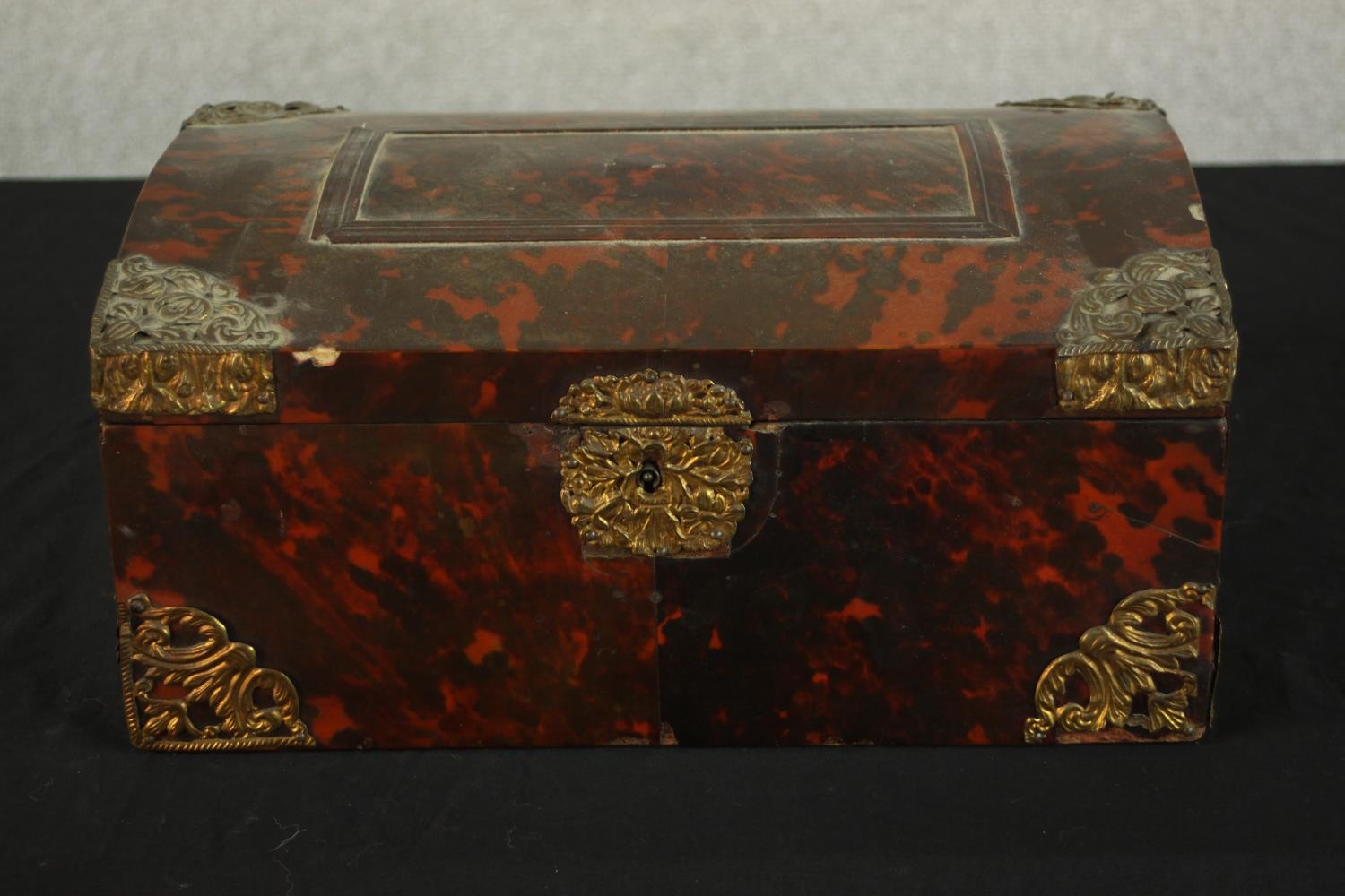A 19th century tortoiseshell mounted dome topped box with brass mounts, opening to reveal velvet
