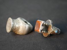 Two Islamic white metal seal rings, one with an orange moulded glass panel with calligraphic