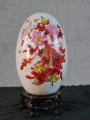 A large Chinese transfer printed and gilded floral and insect design crackle glaze ceramic egg,