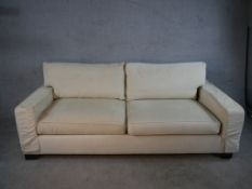 A contemporary Kingcome two seater cream upholstered sofa raised on block feet. H.84 W.120 D.100cm.