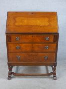 An early 20th century mahogany fall front bureau, opening to reveal fitted interior, raised on